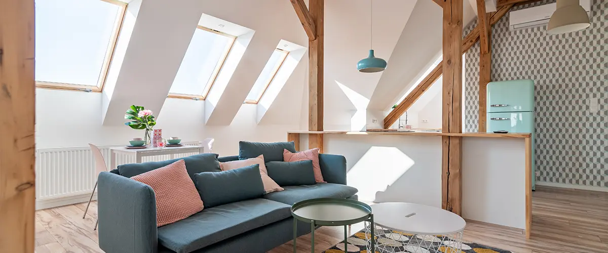 Bright attic living room with textile sofa and coffee table