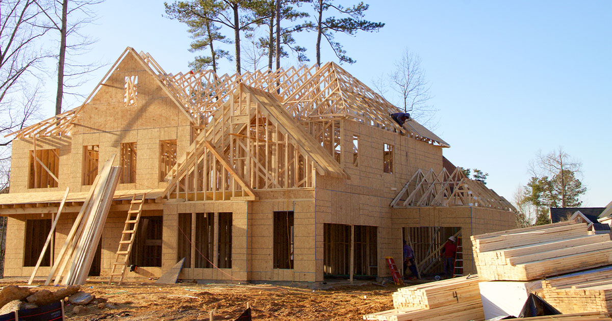 Wooden-two-story-house-under-construction-with-workers-and-building-materials