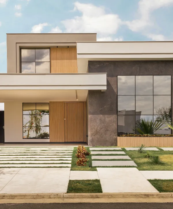 Sophisticated modern home with wood and stone finishes, large windows, and a landscaped front yard.