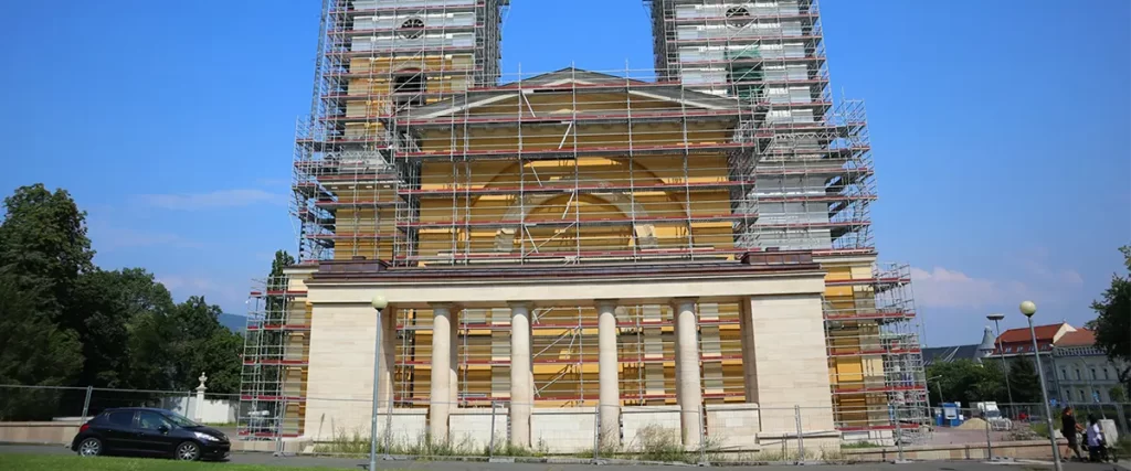 Classical building facade with columns surrounded by scaffolding