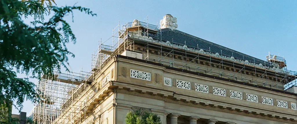 Historic brick building under restoration with heavy scaffolding