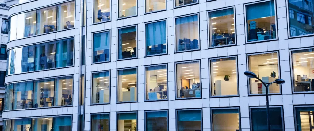 the exterior of a modern office building, characterized by a grid-like facade of white panels and large, non-opening glass windows