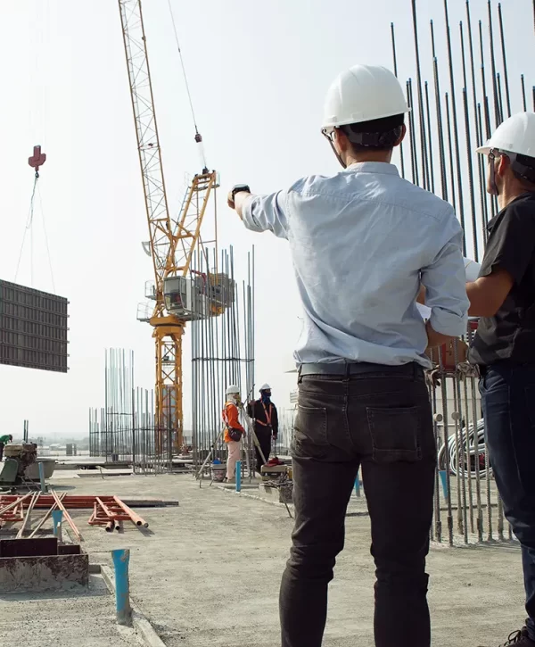 Construction site with workers, crane, and steel structures, showcasing active project management and teamwork.
