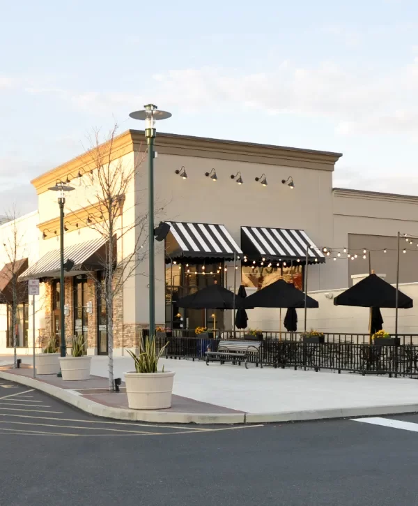 the exterior of a commercial property with several storefronts and an outdoor patio area